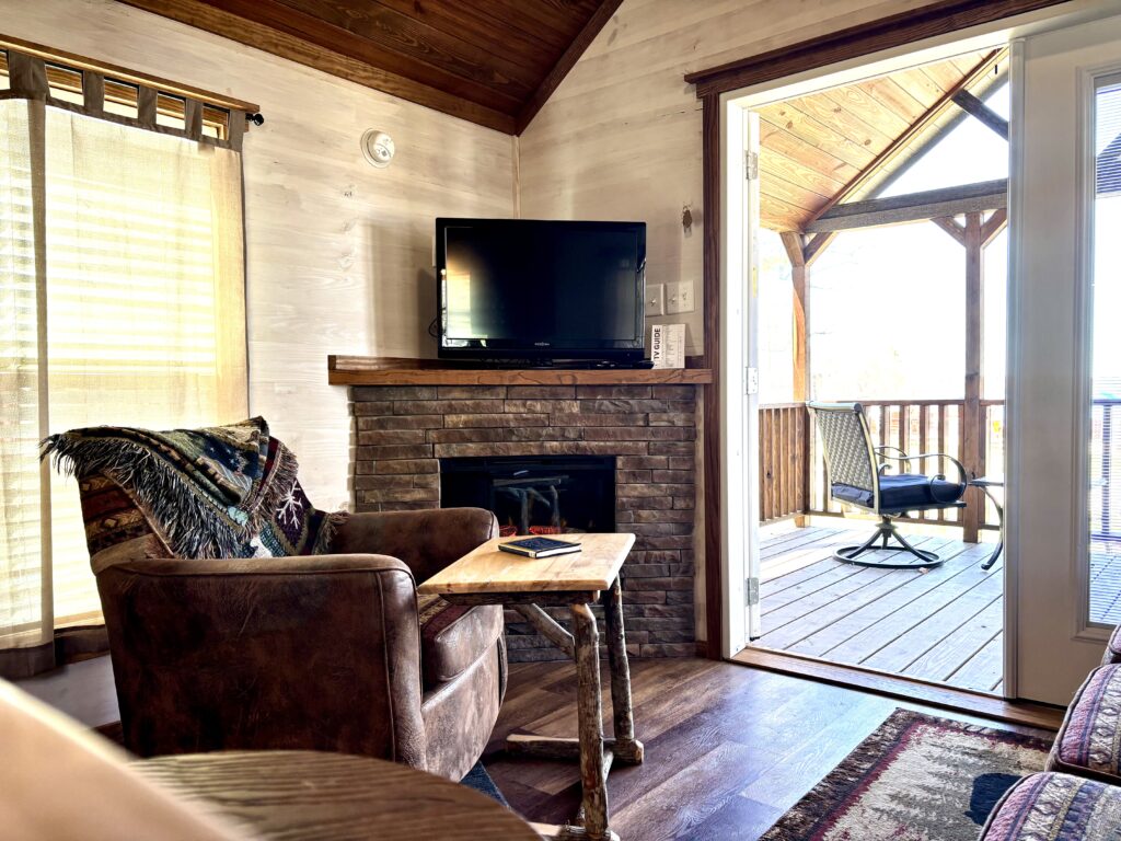 ACC-04 — living room with stone fireplace and covered porch access