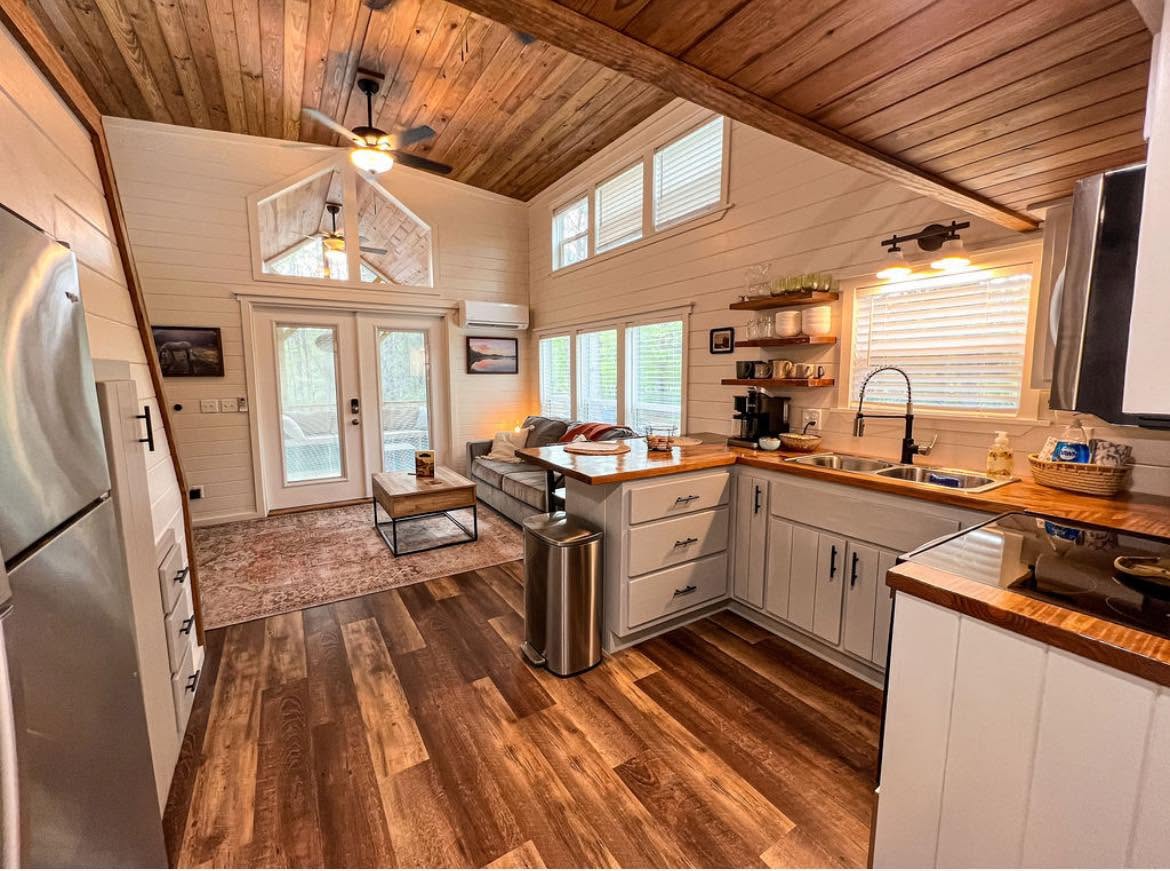 Kelsey 1.0 — open great room with vaulted ceiling and French doors to the porch