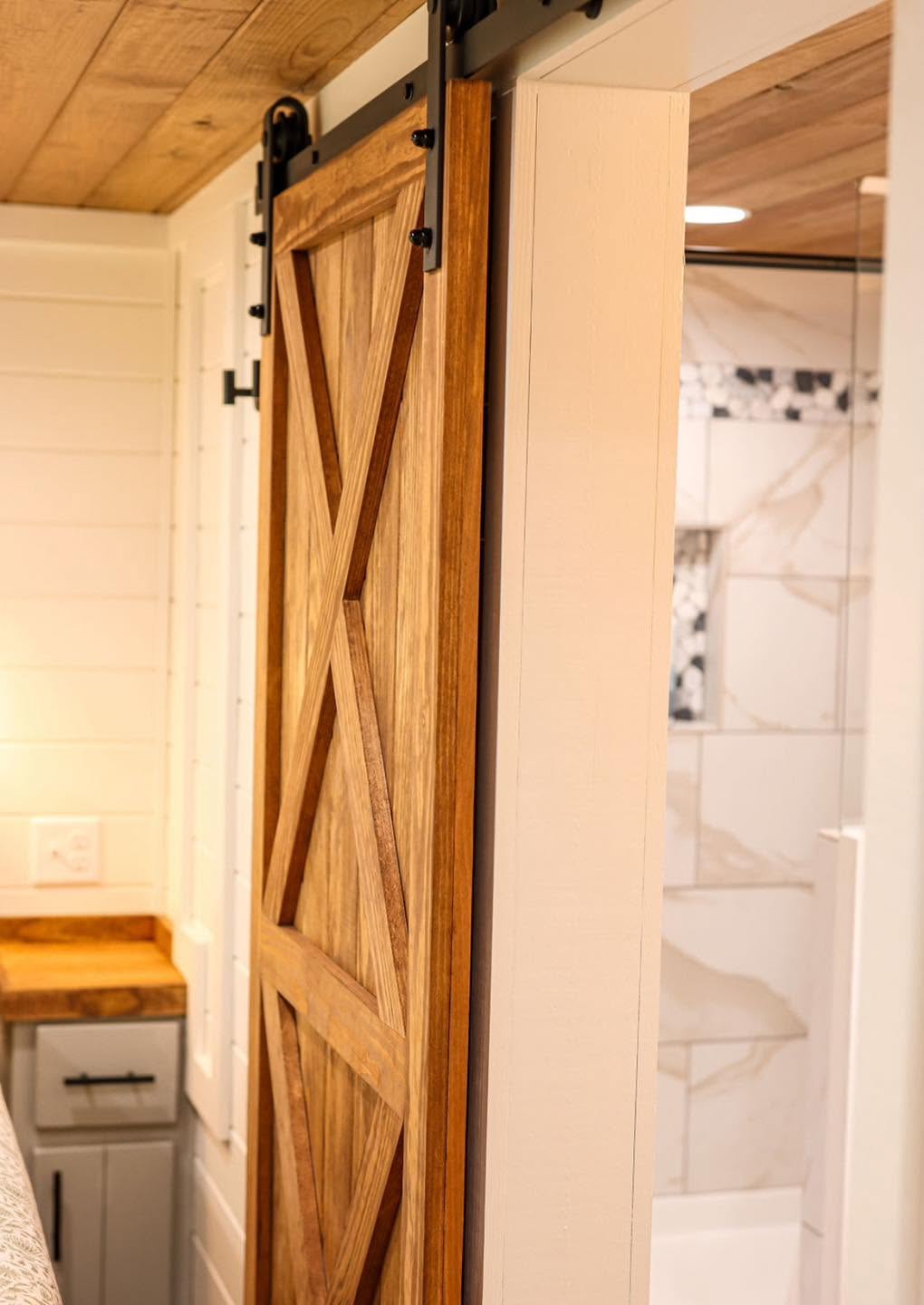 Kelsey 1.0 — barn door opening to the tiled bathroom